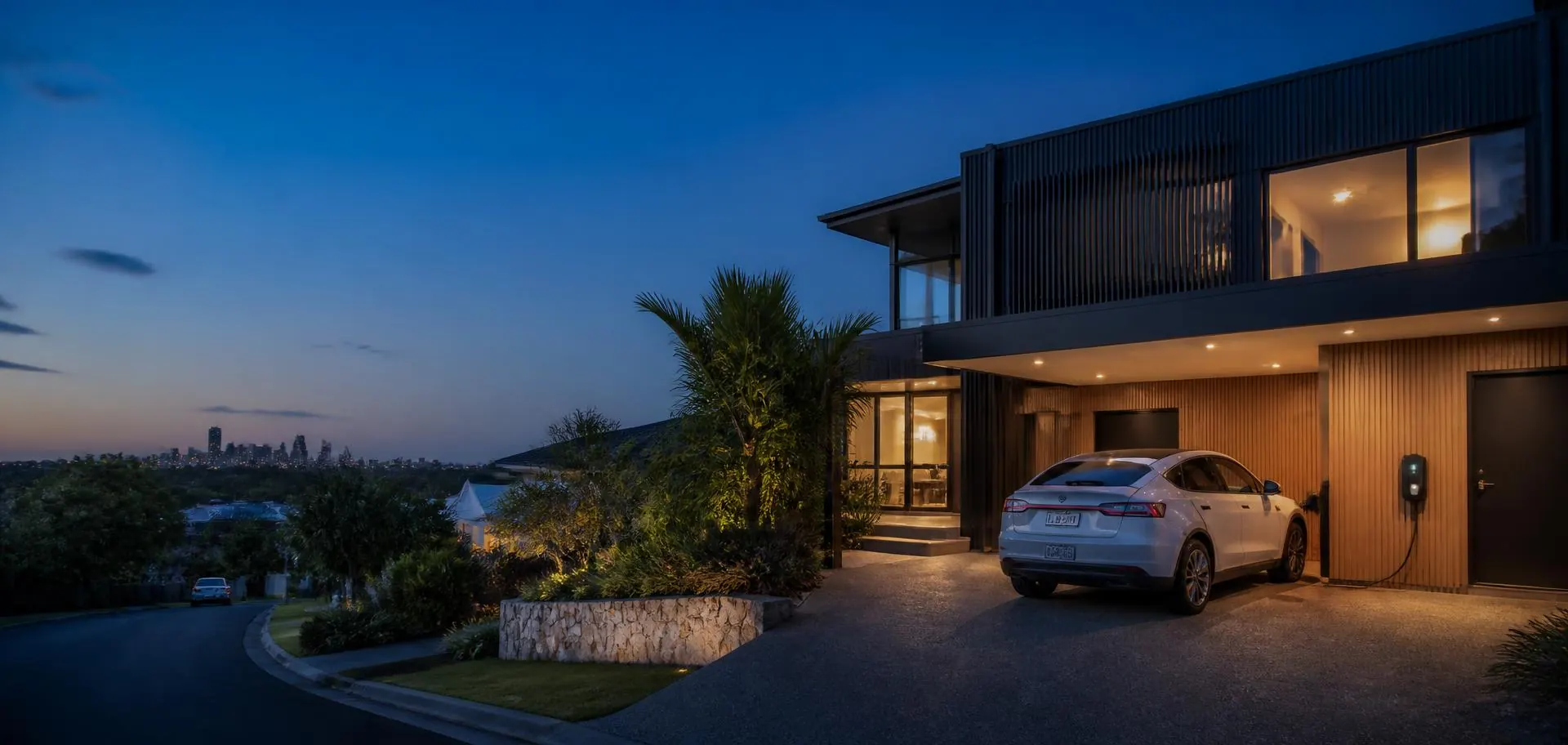Contemporary Newcastle home at dusk with an electric car charging in the driveway